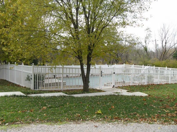White vinyl picket fence around pool